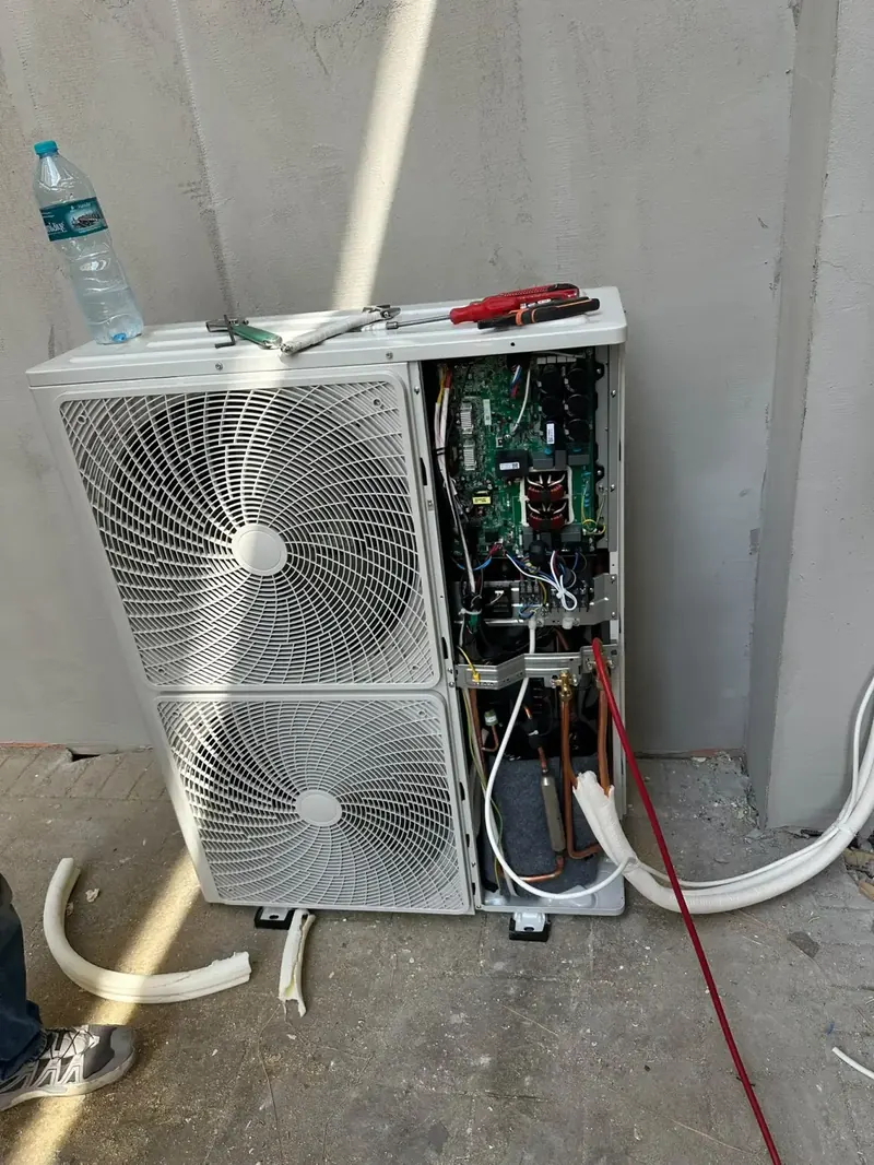 Servis kapağı açılmış çift fanlı klima dış ünitesinde elektronik kart kontrolü